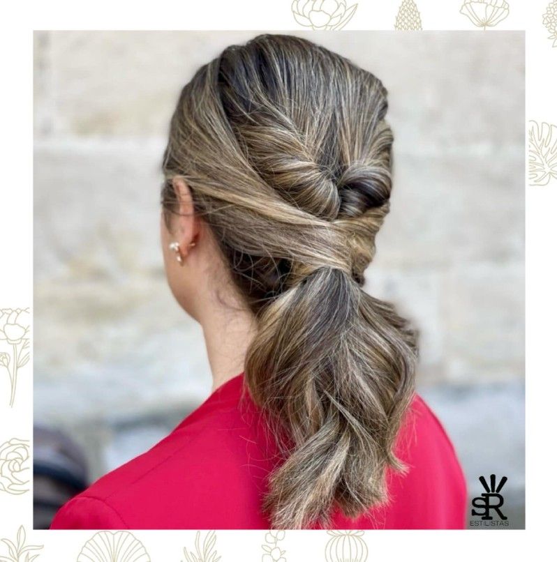 Mujer con peinado recogido, castaño claro con reflejos, anudado en la espalda, top rojo.