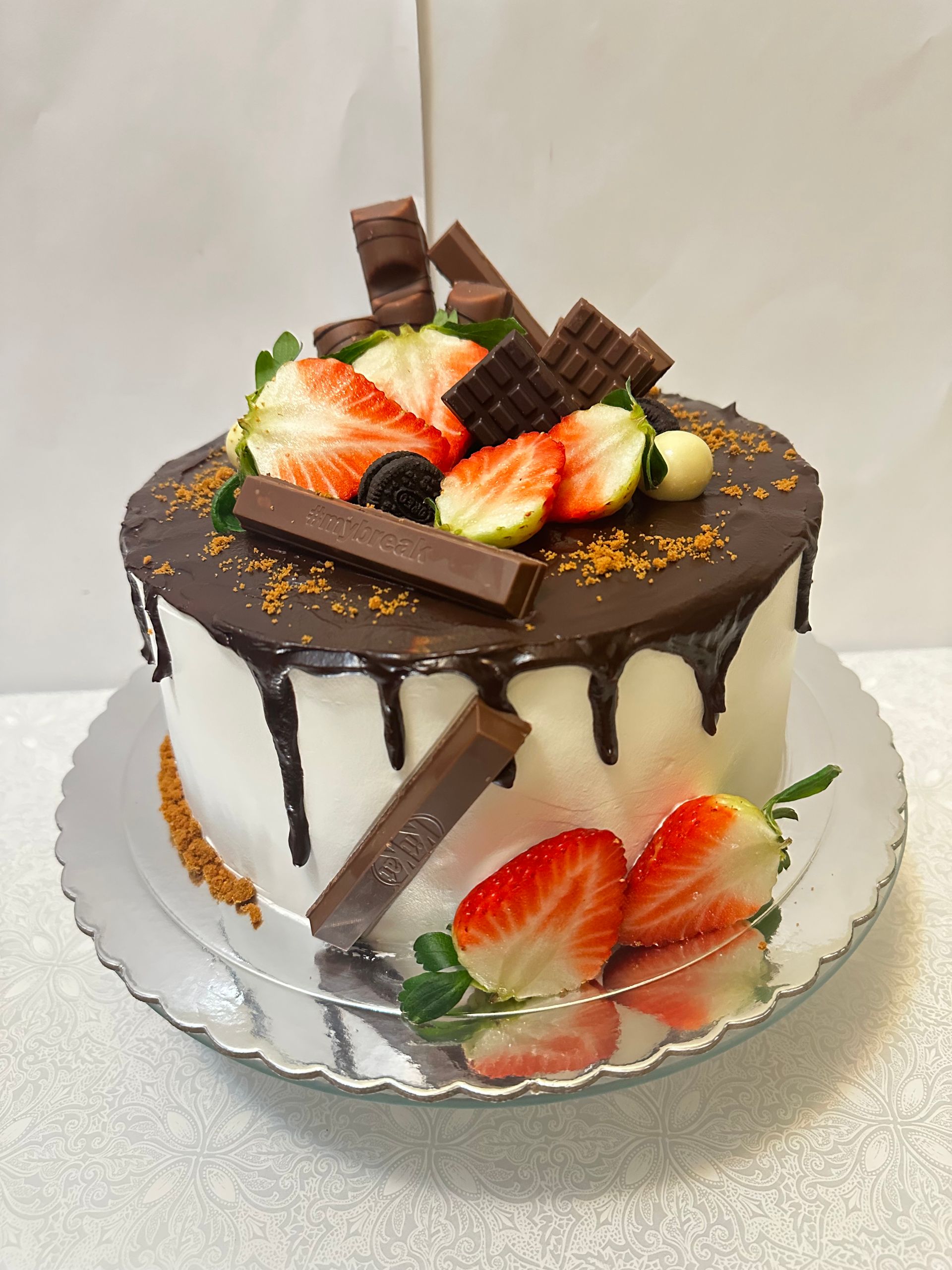 Un pastel con fresas y chocolate encima.