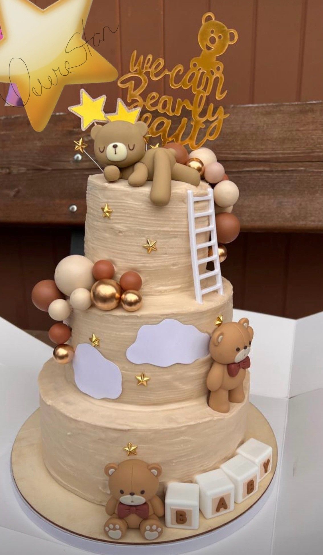 Un pastel de tres niveles con ositos de peluche y globos.