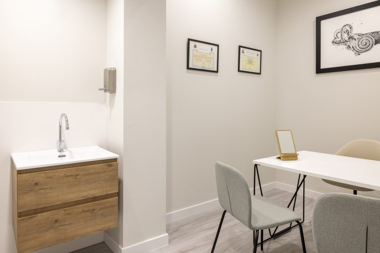 Una habitación con una mesa y sillas y un lavabo.