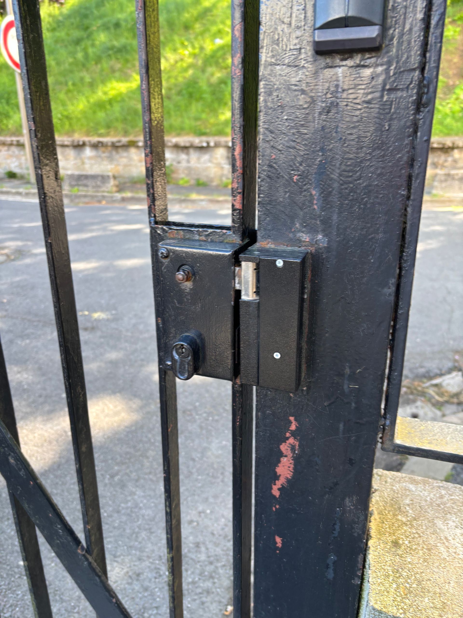 Système de fermeture sur un portail résidentiel en métal, à la peinture écaillée