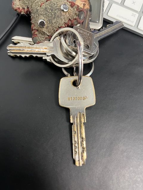 Trousseau de clés posé sur un bureau, à côté d'un clavier d'ordinateur Mac.