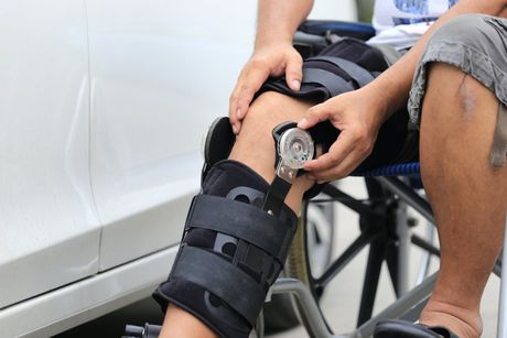 Homme  jambe allongée équipée d'une attelle