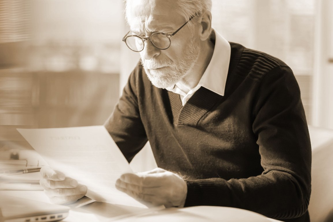 Homme âgé contrarié étudiant un document