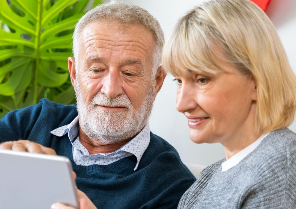 Couple senior en train de regarder une tablette
