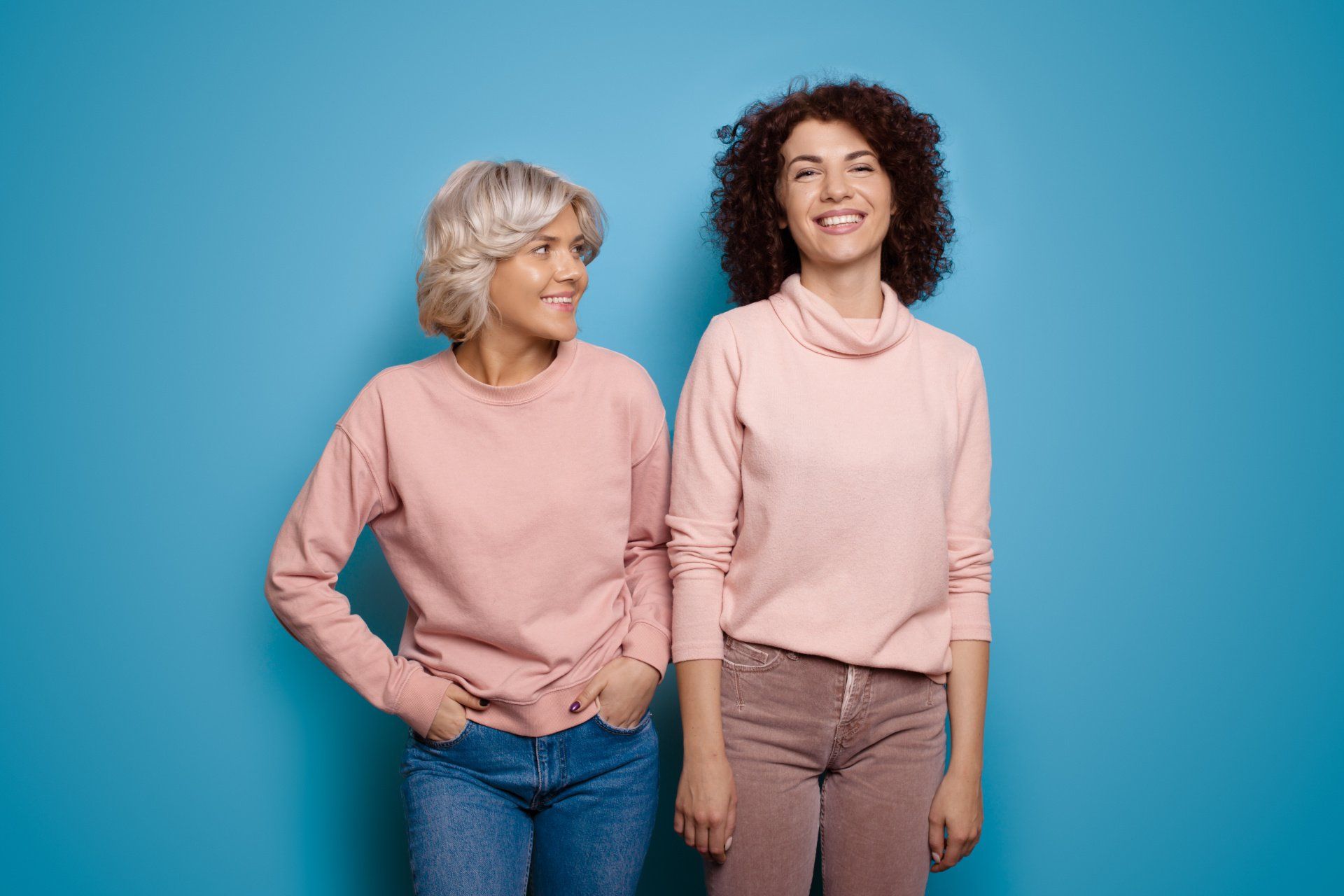 Femmes jeunes, dont l'une avec une perruque blonde platine, fond bleu océan
