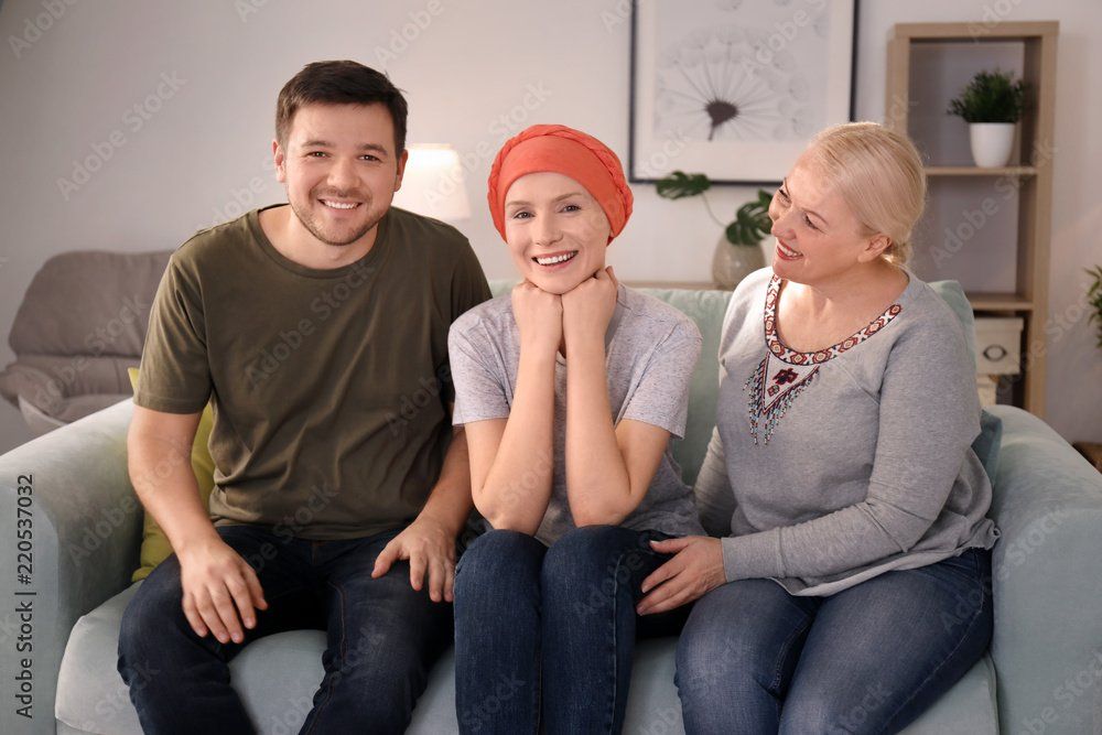 Femme jeune entourée d'un homme et d'une autre femme, elle porte un turban orange sur la tête