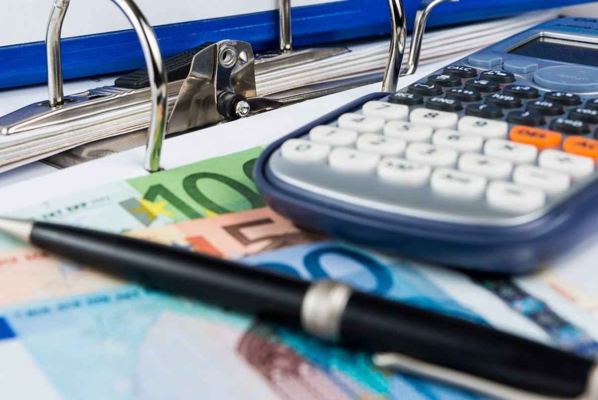 Billets de banque, stylos et calculette
