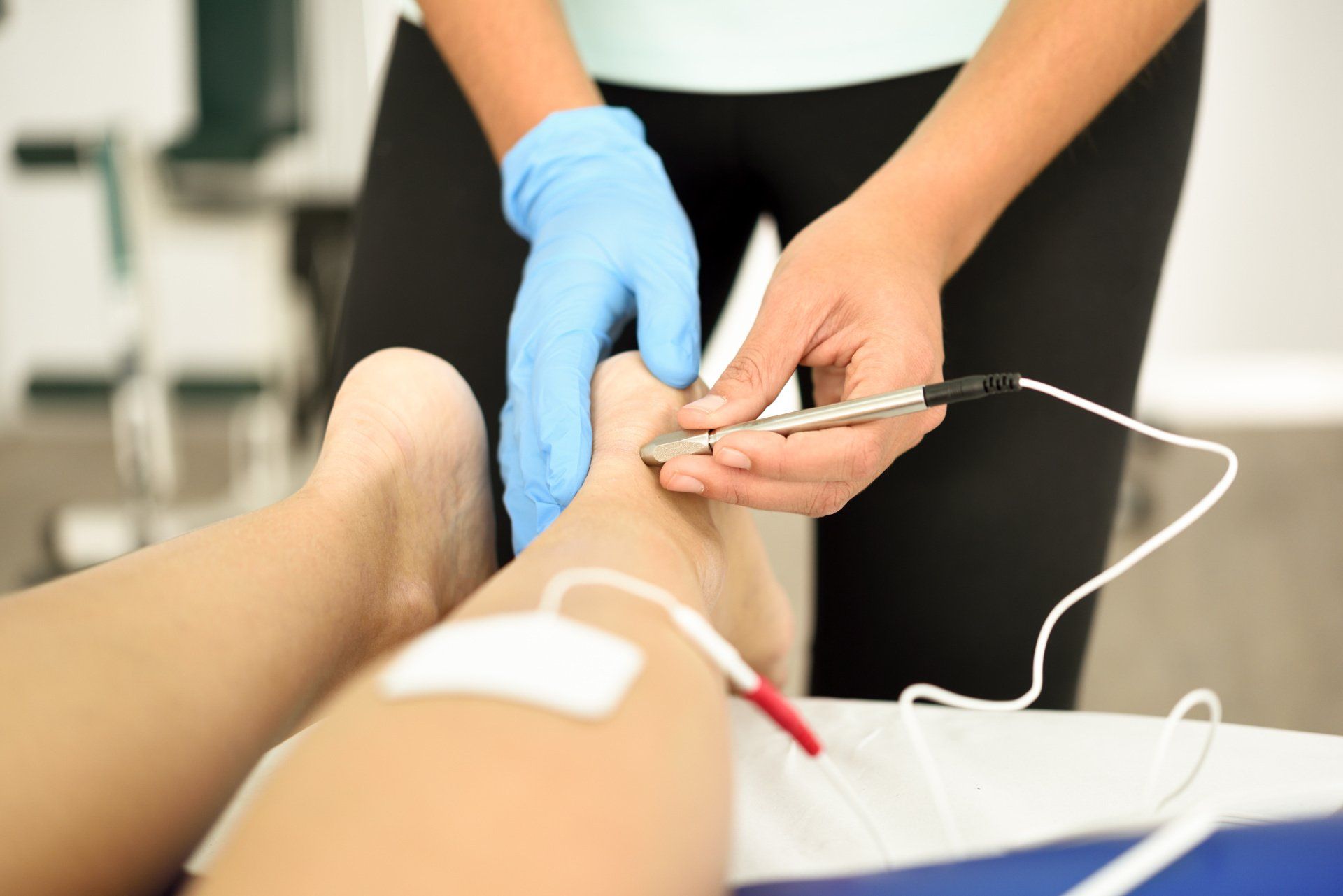 Pose d'électrodes sur jambe et cheville d'une personne sur le ventre