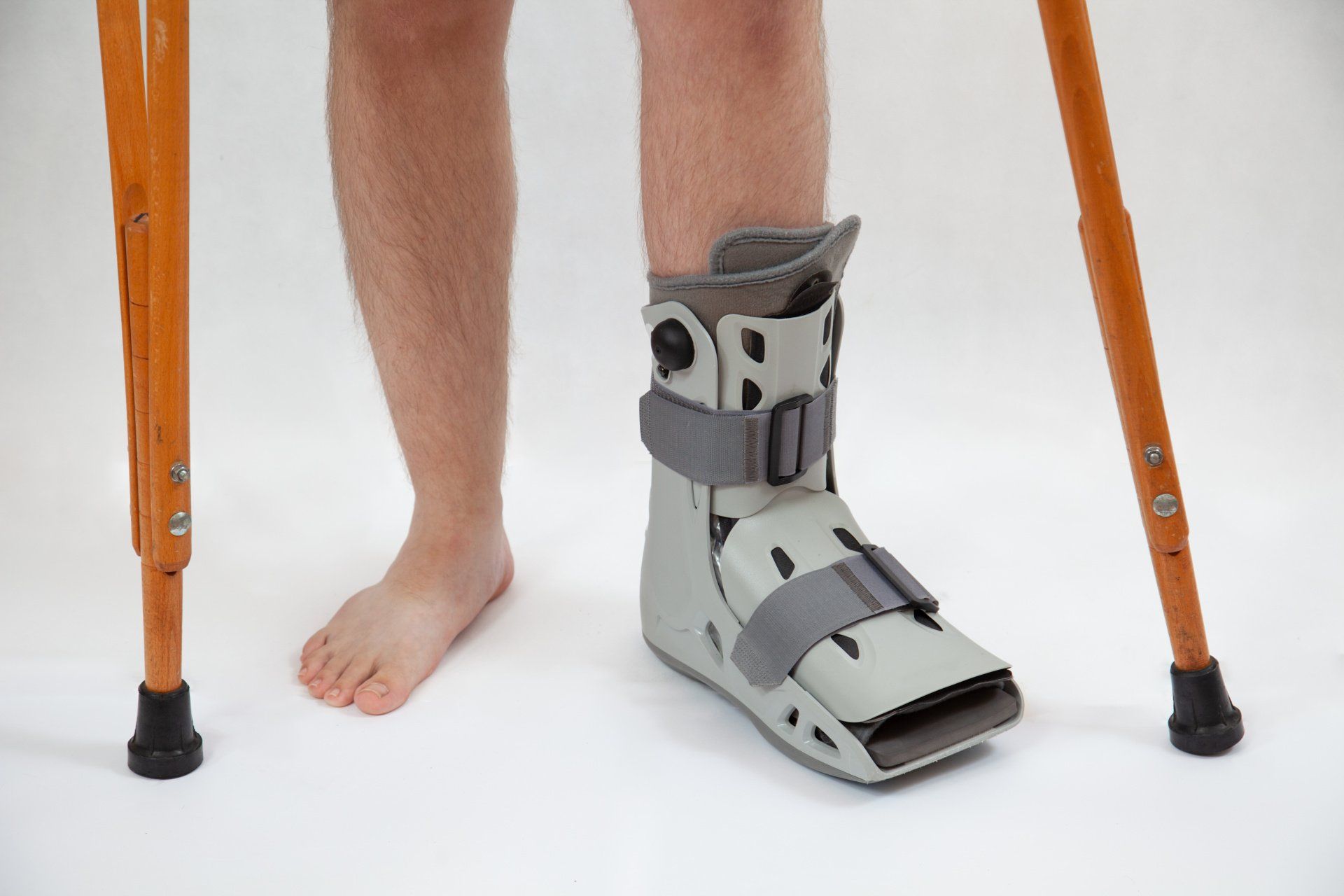 Homme avec botte d'immobilisation et cannes anglaises