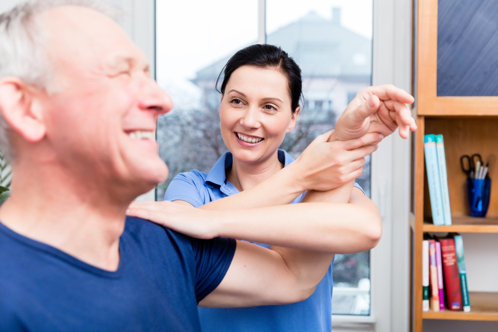 Femme médecin avec homme senior souriant levant le bras