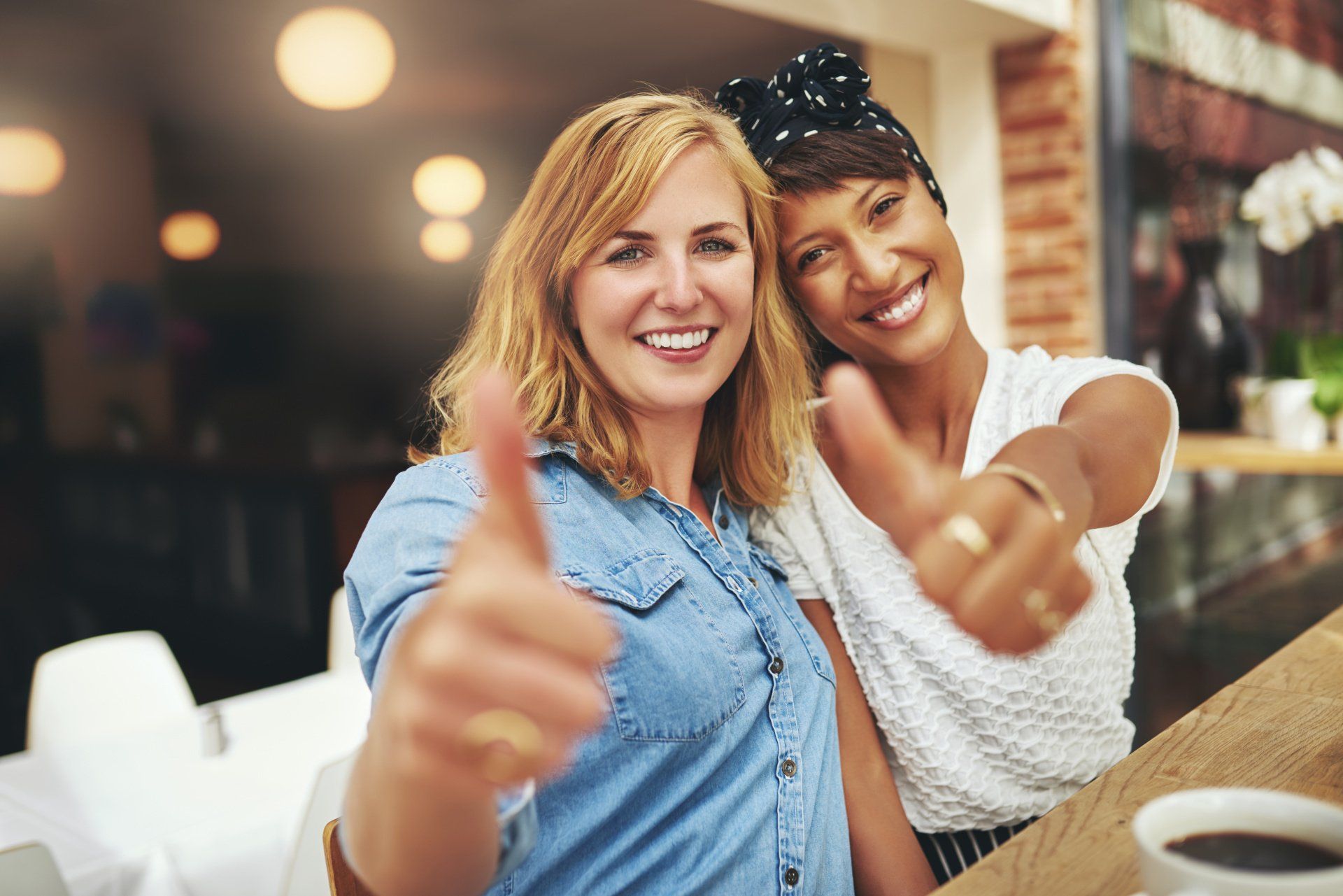 Femmes souriantes et levant toutes les deux le pouce