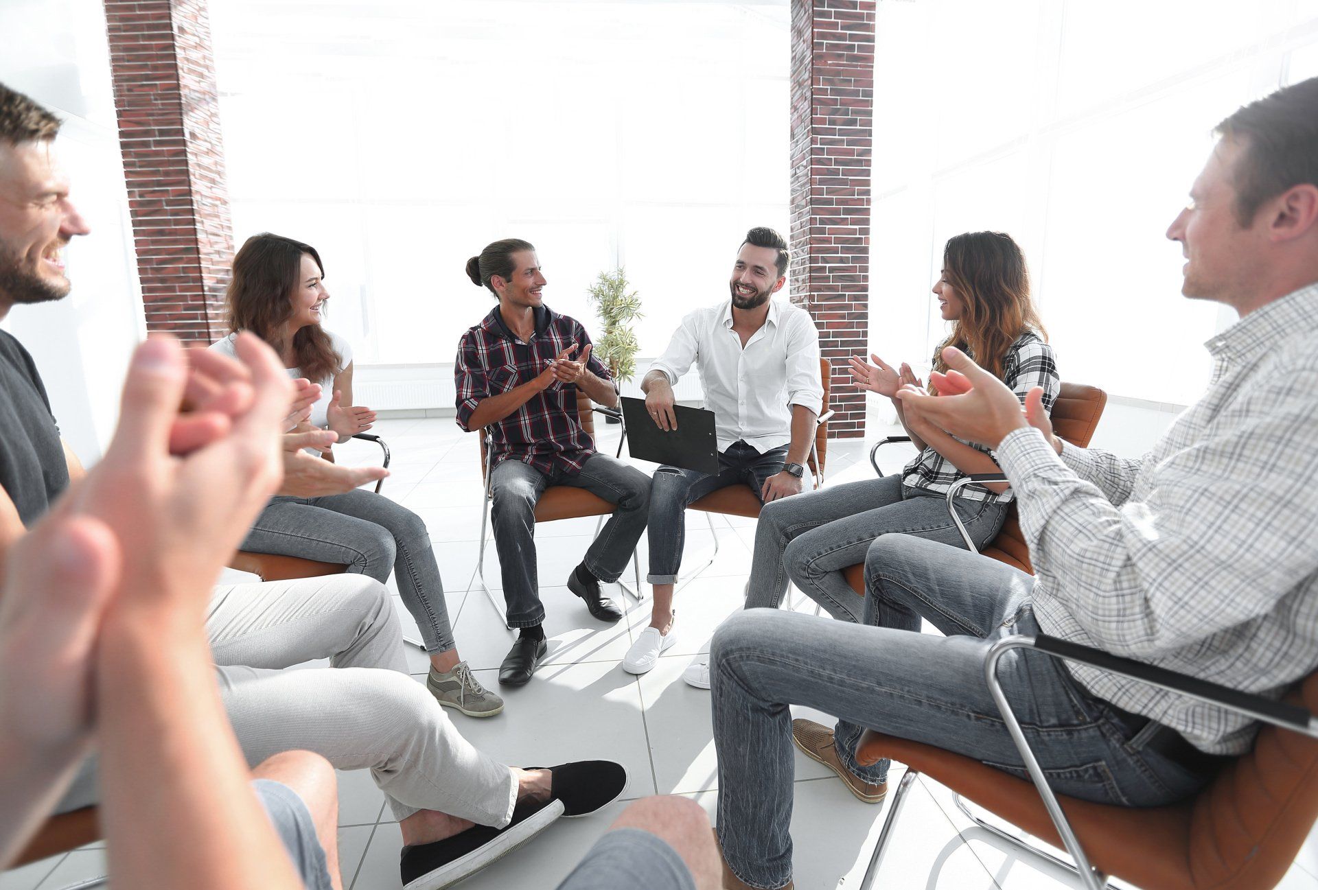Réunion d'hommes et de femmes assis souriant et ayant des échanges