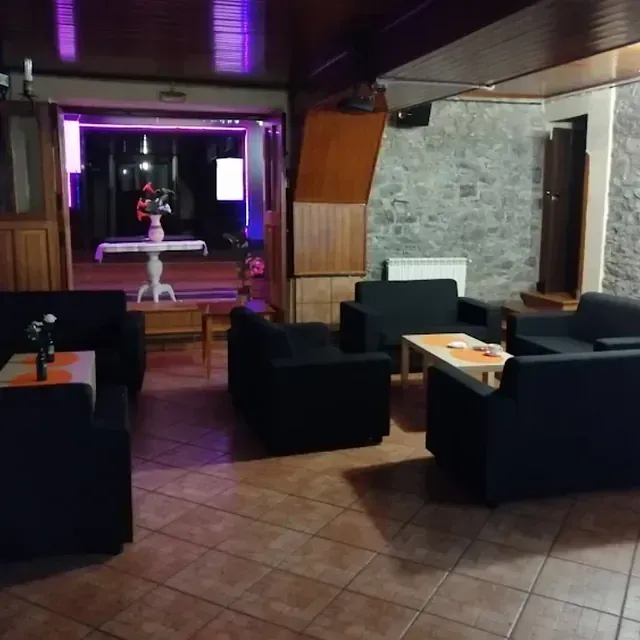 Una sala de estar con sillas negras y una mesa.