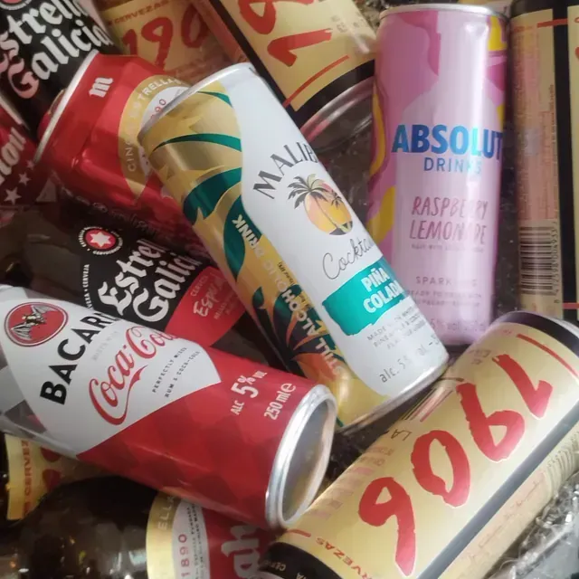 Un montón de latas de alcohol, incluyendo Bacardi, Coca Cola y Absolut.