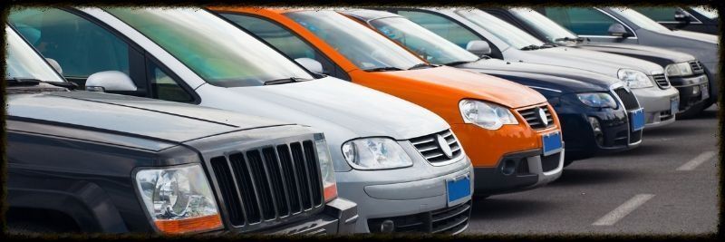 Una fila de coches están estacionados en un estacionamiento.