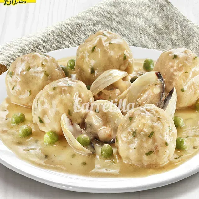 Un plato blanco cubierto con albóndigas y guisantes verdes dice barreilla