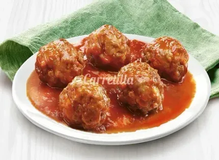 Un plato blanco cubierto con albóndigas en salsa de tomate.