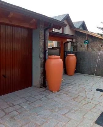 Dos ollas de barro están delante de una puerta de garaje.