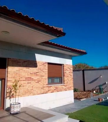 Una casa de ladrillo con una planta en maceta delante de ella.