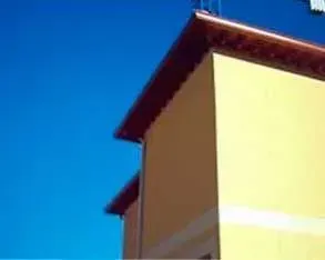 Un edificio amarillo con un techo rojo y un cielo azul en el fondo.