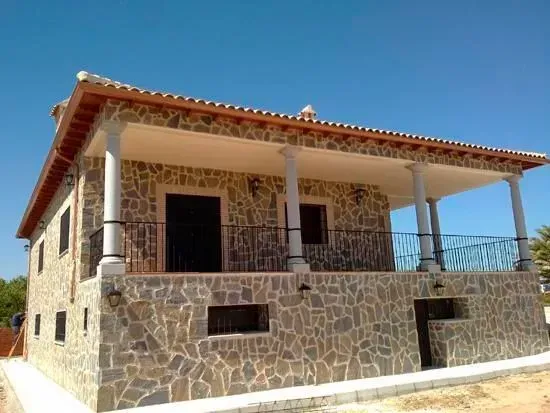 Una gran casa de piedra con balcón y columnas.
