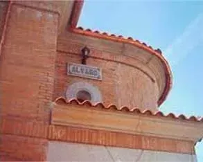 Un edificio de ladrillo con un cartel al costado que dice Álvarez.