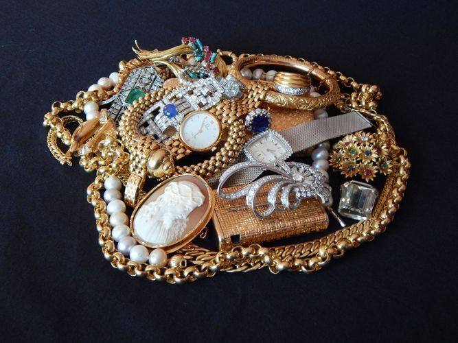 Un tas de bijoux en or : colliers, bracelets, broches, une montre et un camée.