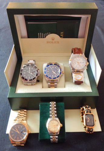 Six montres Rolex présentées dans un coffret vert. Deux rangées de montres ; certaines sont en acier inoxydable et or, d’autres serties de diamants.