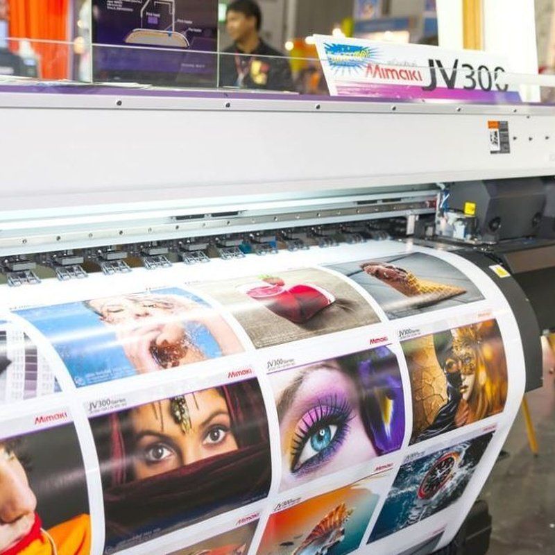 Impresora de gran formato que imprime imágenes a color de ojos, retratos y más. Máquina blanca y gris.