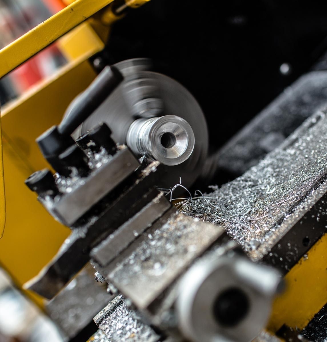 Un primer plano de un torno cortando una pieza de metal.