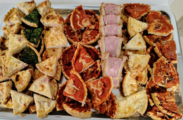 Assortiment de quiches et pâtés en croûte sur un plateau.