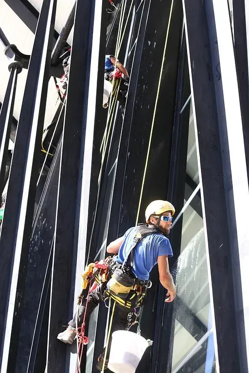 Cordiste lavant une baie vitrée