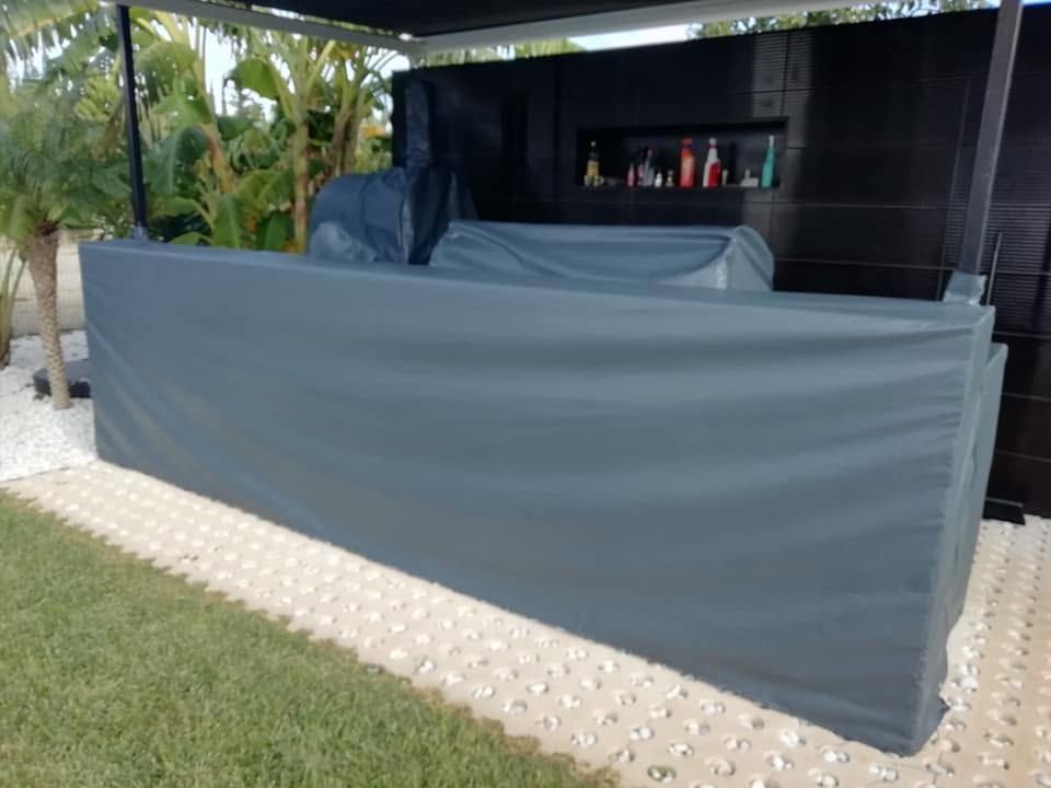Zona de bar al aire libre con mamparas grises para mayor privacidad, estantes negros