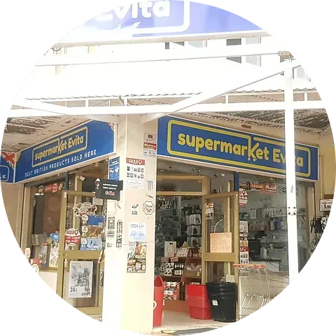 Entrada del supermercado Evita con carteles azules y amarillos, mostrando diversos artículos en su interior.