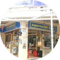 Entrada del supermercado Evita con carteles azules y amarillos, mostrando diversos artículos en su interior.