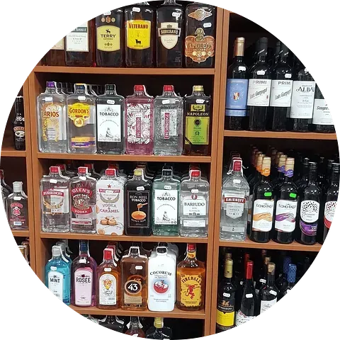 Estantes llenos de varias botellas de licor en un entorno de tienda.