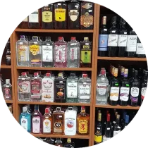 Estantes llenos de varias botellas de licor en un entorno de tienda.