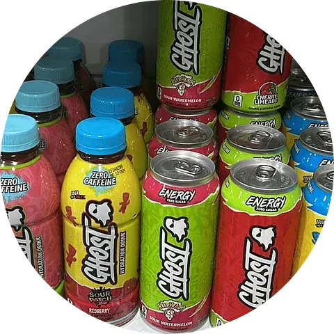 Surtido de bebidas energéticas Ghost en latas y botellas, varios colores y sabores, en un estante.
