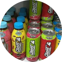 Surtido de bebidas energéticas Ghost en latas y botellas, varios colores y sabores, en un estante.