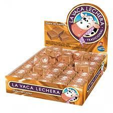 Caja expositora de dulces de leche La Vaca Lechera, con mascota vaca y empaque dorado.