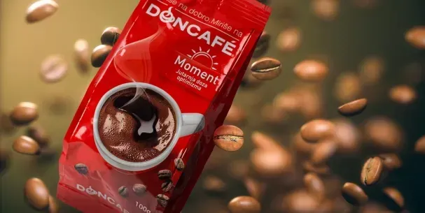 Paquete de café rojo con una ilustración de una taza de café, rodeada de granos de café sobre un fondo verde borroso.