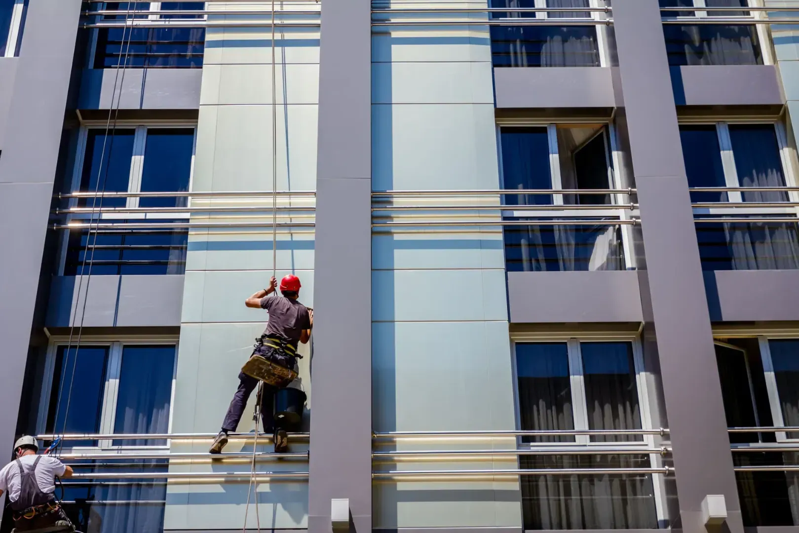 Un hombre está subiendo por el costado de un edificio.