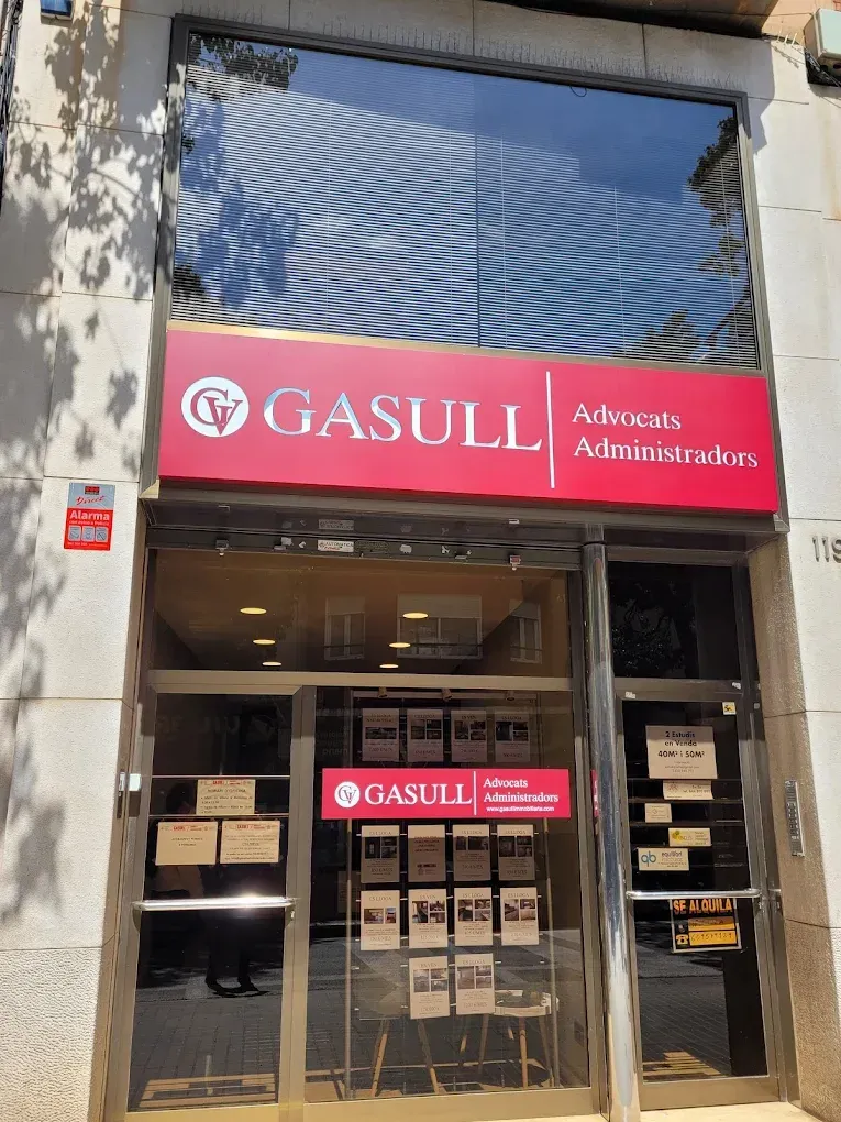 Escaparate del bufete de abogados Gasull con cartelería roja y puertas de cristal.