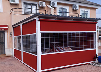Un edificio rojo y blanco con muchas ventanas y aires acondicionados.