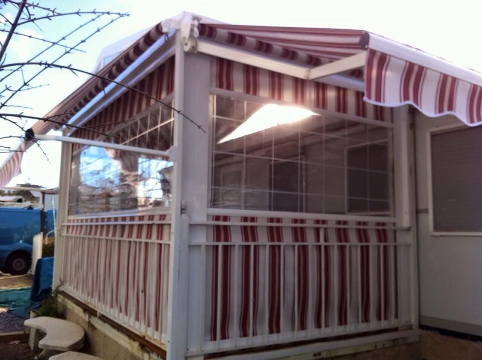 Un toldo de rayas rojas y blancas sobre un porche cubierto.