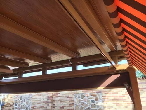 Un toldo de rayas rojas y blancas cuelga del techo de una estructura de madera.