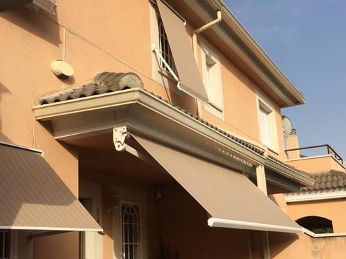 Una casa con un toldo al costado.