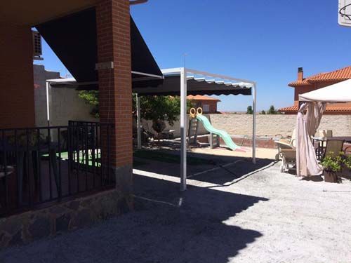 Un patio con sombrillas y un tobogán al fondo.