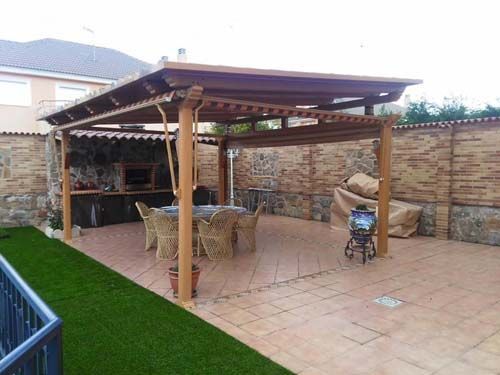 Un patio con pérgola de madera, mesa y sillas, y un cochecito.